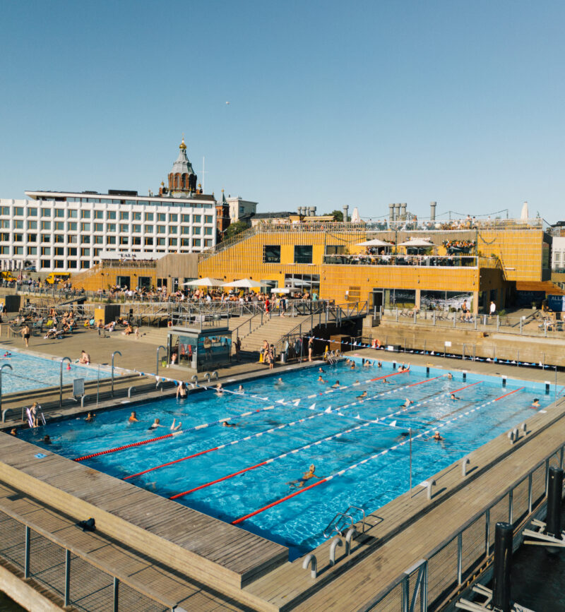 Allas Sea Pool — main heated pool with swimmers in summer, Helsinki Cathedral behind