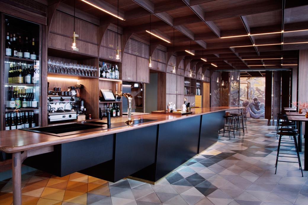 Arakataka — Matbaren bar section with timber counter, vaulted ceiling and patterned tile floor