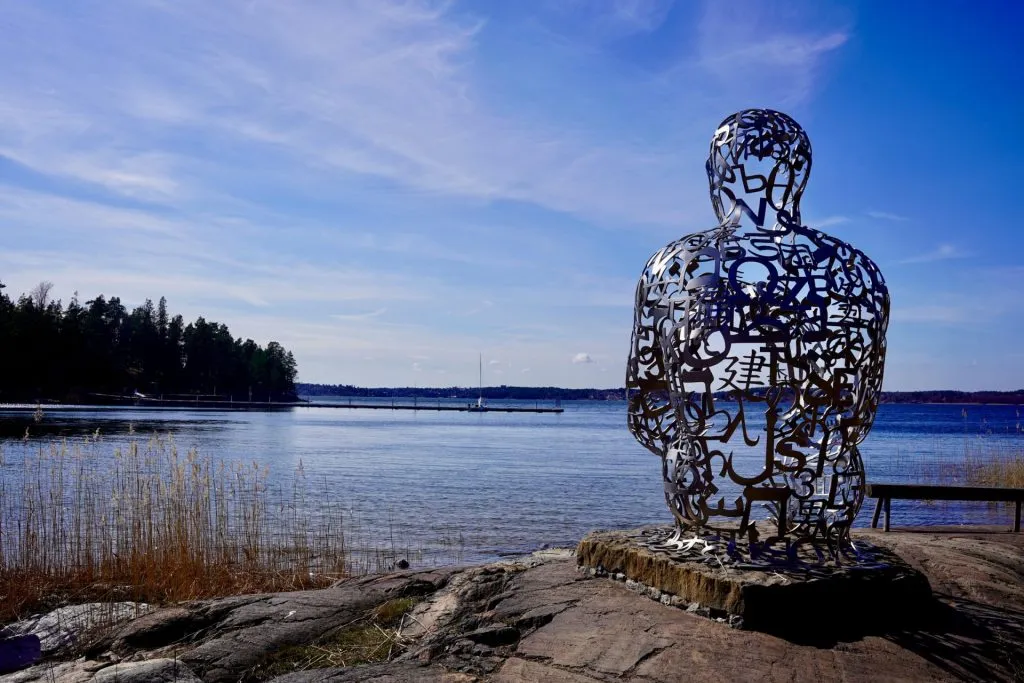 Artipelag — Jaume Plensa sculpture seated on the granite shoreline facing the water
