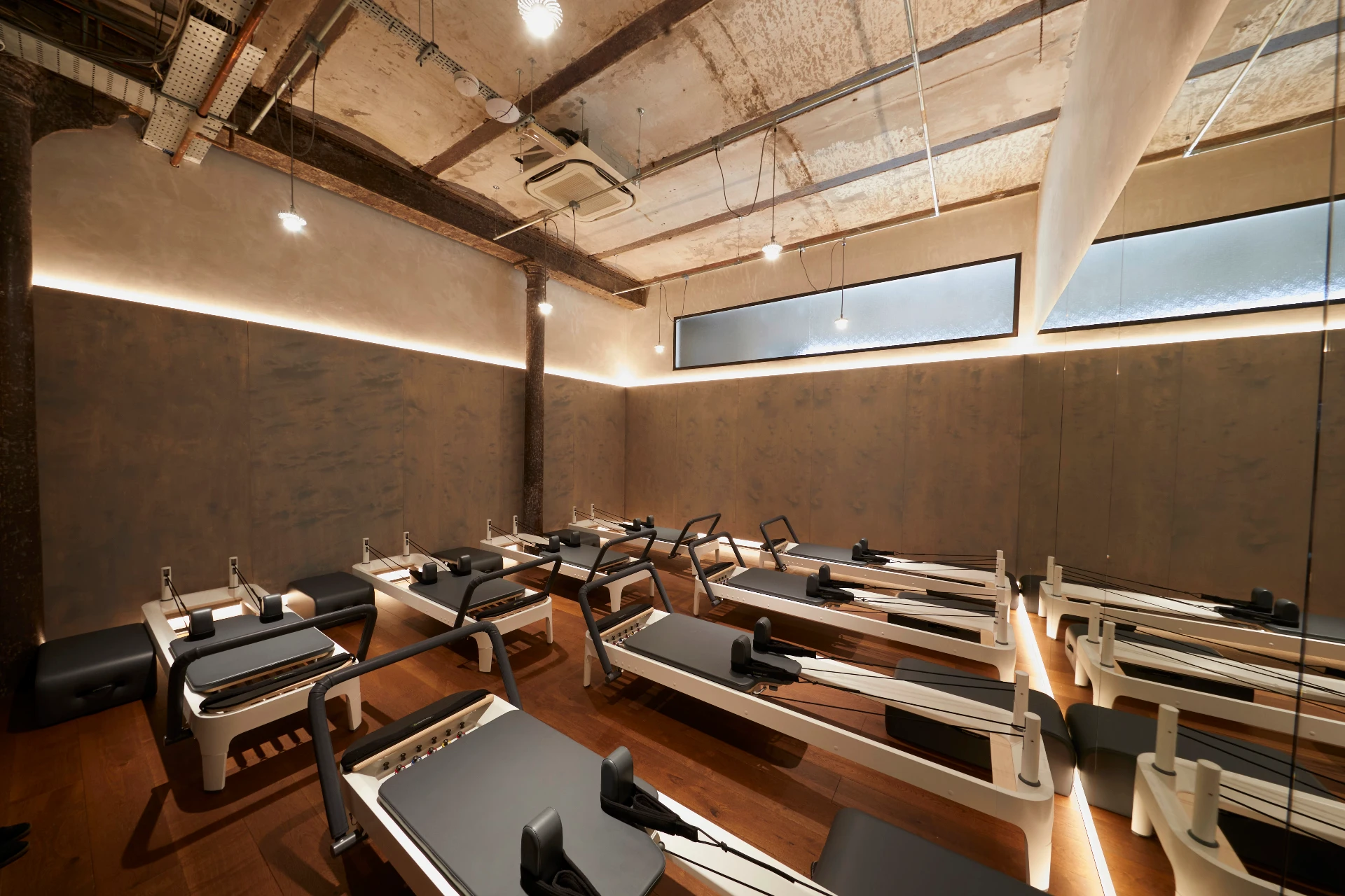 BLOK Clapton reformer studio — rows of reformers under warm lighting in the converted depot