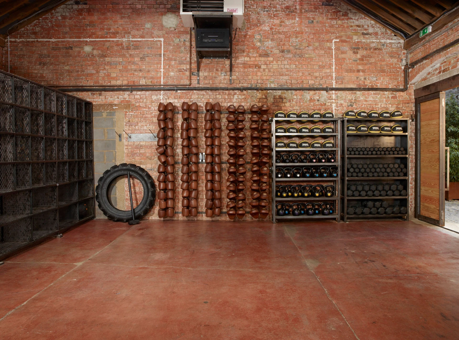 BLOK Clapton — the converted Victorian tram depot interior, exposed brick, kettlebells and Lonsdale pads racked along the wall