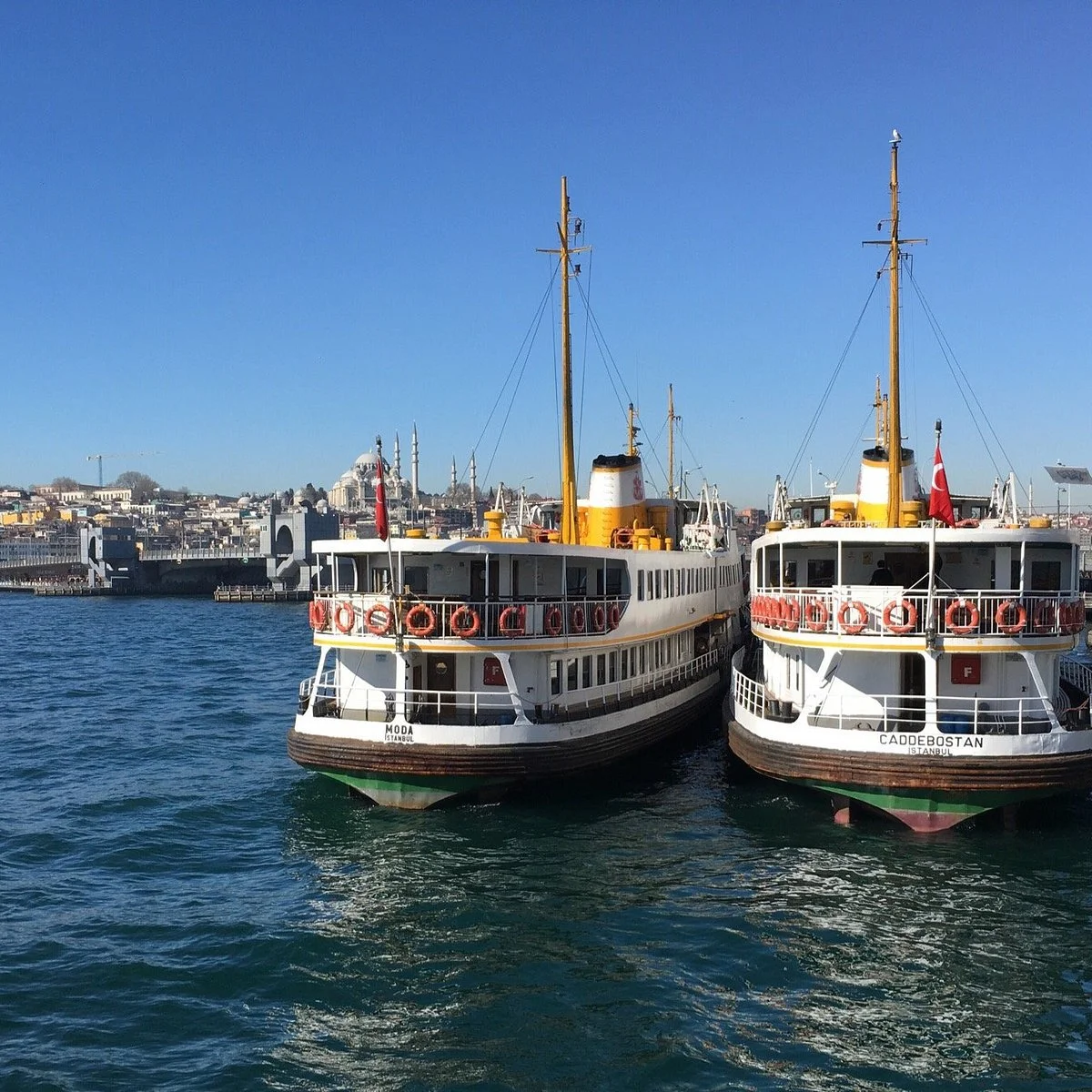 Two Şehir Hatları ferries moored at the pier in Karaköy, the old city skyline across the Golden Horn