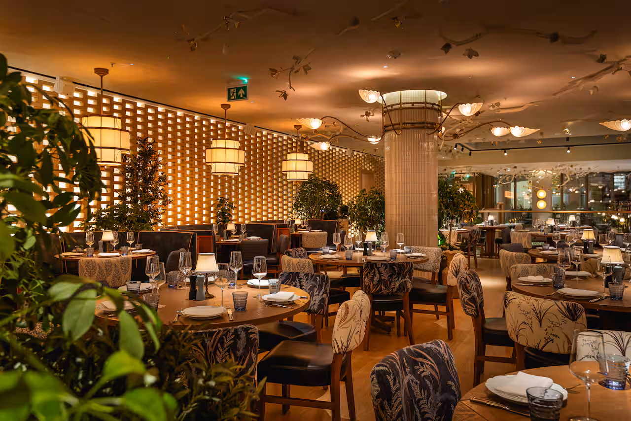 An interior at The BoTree, Marylebone — wood-panelled walls, warm greens and cognacs, art on the walls and floral motifs that reference the area's history with the flower trade