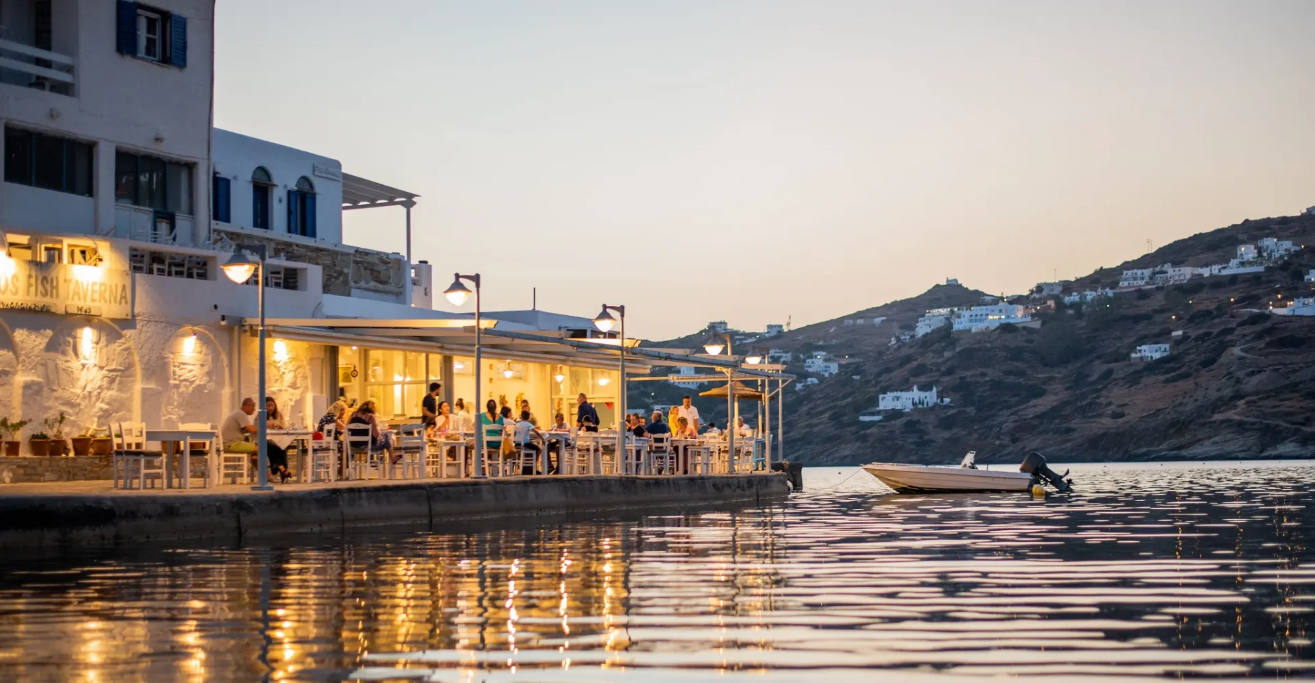 Drakos Taverna — sunset waterfront tables at the far southern end of Mylopotas beach, Ios
