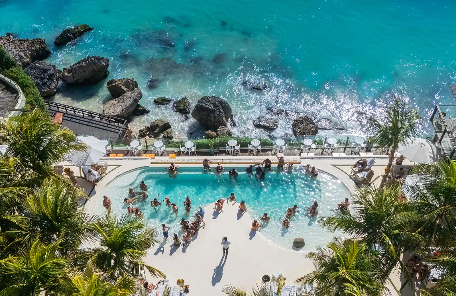 El Kabron Bali — aerial view of the Hedonism Lounge infinity pool above the Indian Ocean at Pecatu, Uluwatu, during a live afternoon performance