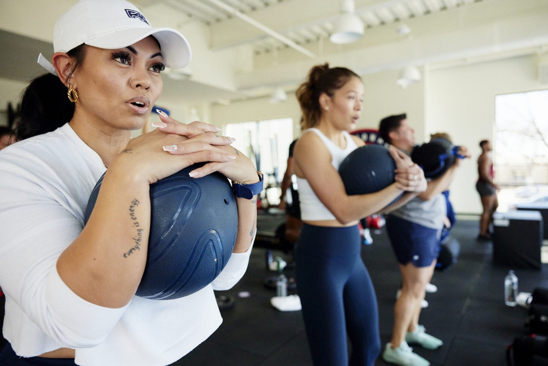 F45 members training with medicine balls in a group session