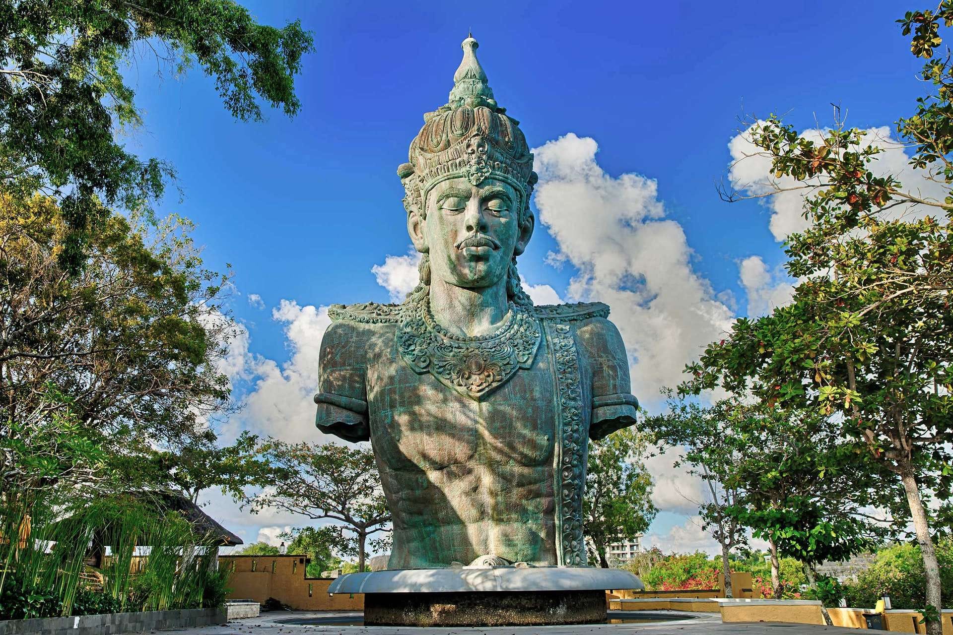 Original Vishnu bust at Garuda Wisnu Kencana Cultural Park framed by trees on the Bukit Peninsula