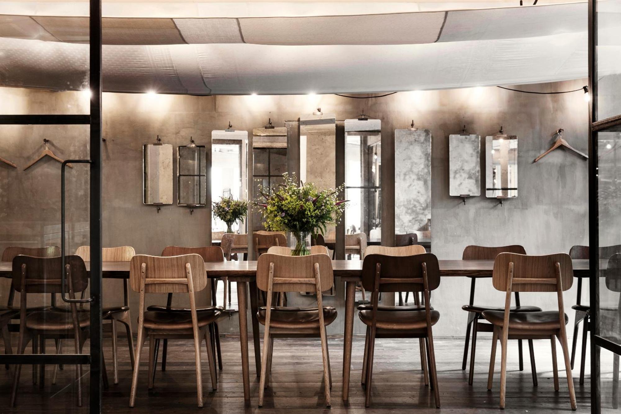 Hotel SP34 — communal dining room with long timber tables and concrete walls