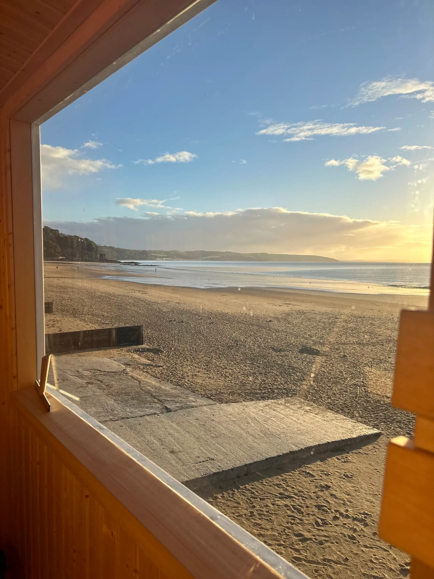 Beach view through window at Hwyl Sauna
