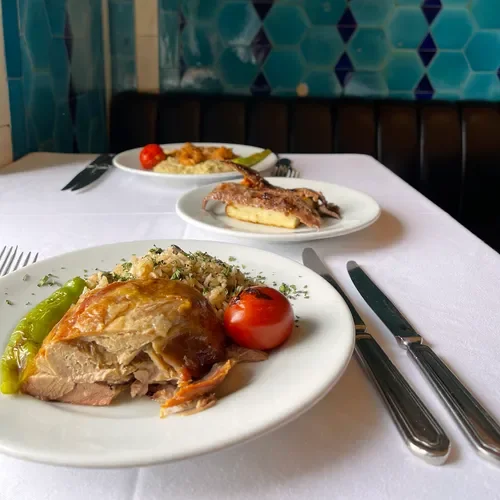 Plates at Pandeli — lamb with rice, tomato and green pepper, set on white linen against the turquoise tiles