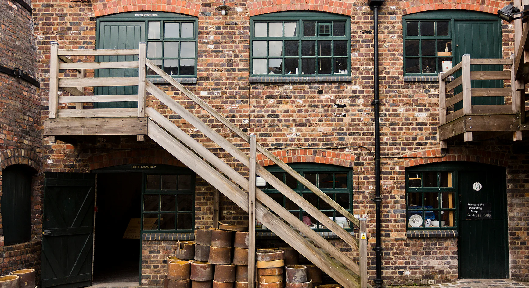 Historic Stoke-on-Trent pottery factory exterior with brick walls and wooden staircase