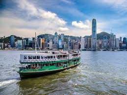 A Star Ferry seen from the Kowloon side of Victoria Harbour with the Central skyline of Hong Kong Island in the background