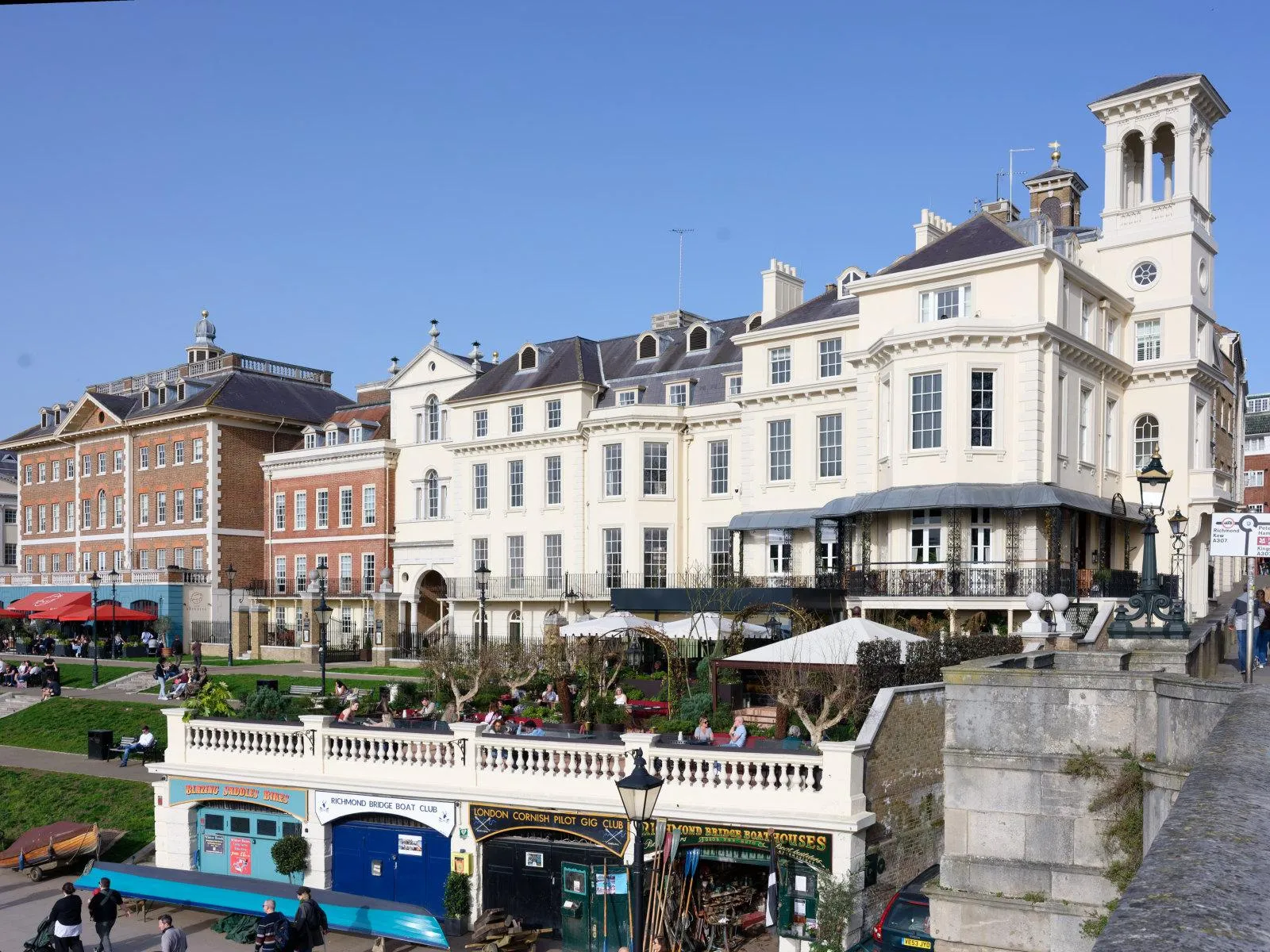 Tower House, Richmond — the restored 19th-century clocktower on Richmond Bridge, its cream stucco frontage and belvedere tower rising above the Thames-side terrace and boat houses