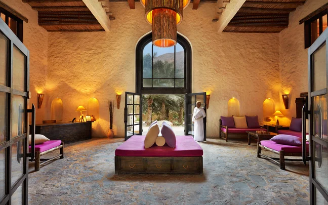 Six Senses Zighy Bay — Sablah lobby interior with arched doorway, basket chandeliers and traditional Omani stonework