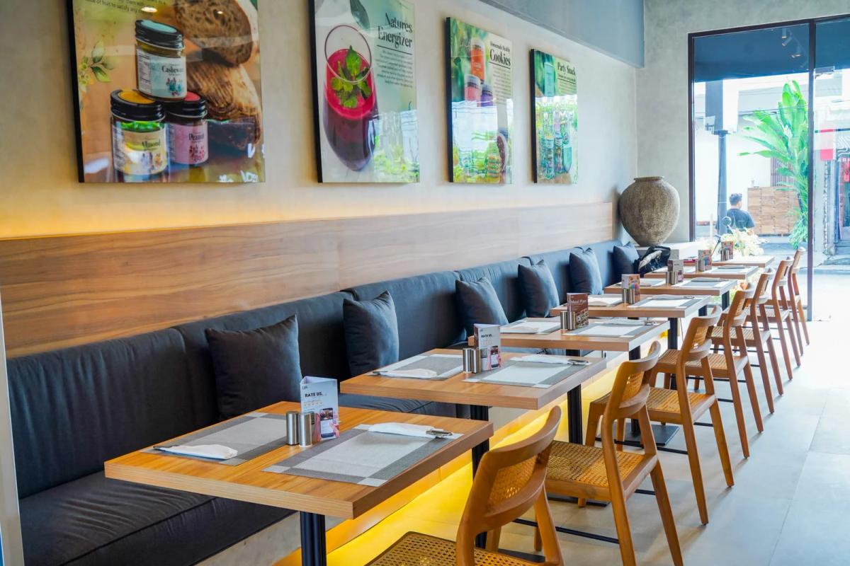 Terra Berawa — wellness eatery interior with banquette seating and wooden tables