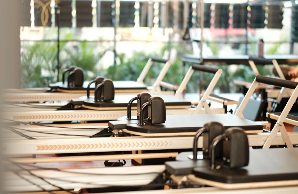 Native Bali Pilates, Canggu — STOTT-style reformers in a sunlit studio with garden visible through full-height windows