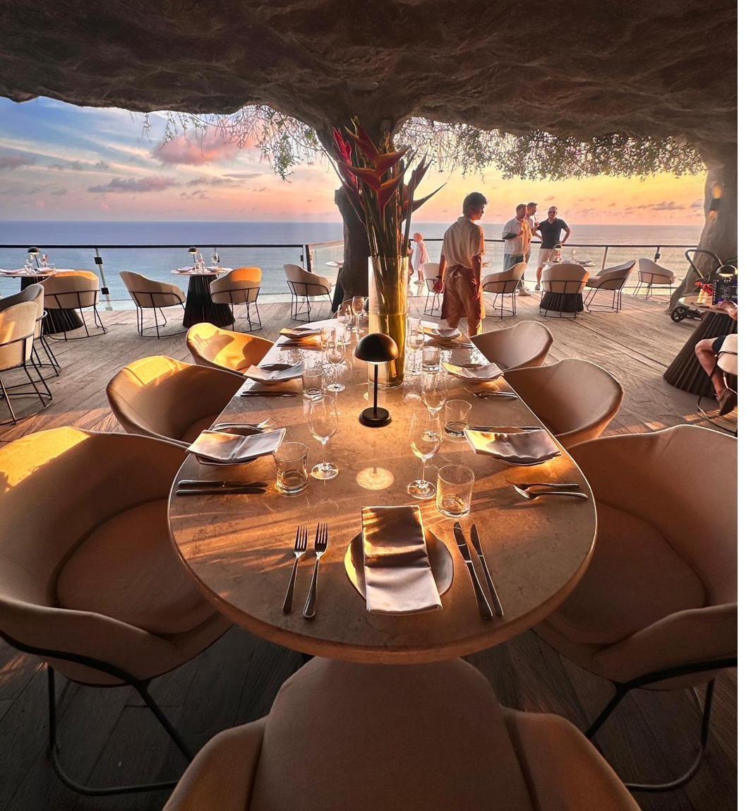Rockfish, Uluwatu — cave-set restaurant on the cliff above the Indian Ocean with the boardwalk framed by sunset