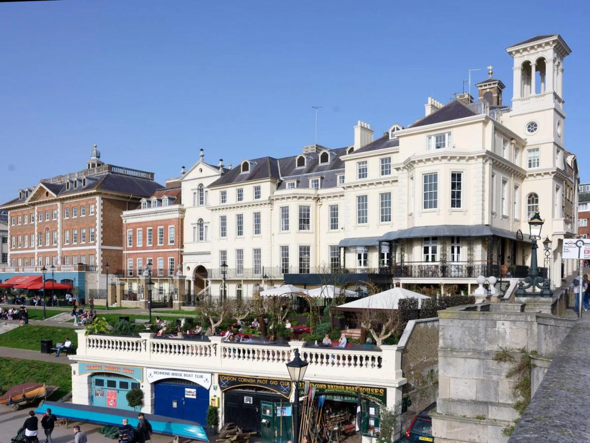Tower House, Richmond — the restored 19th-century clocktower on Richmond Bridge, its cream stucco frontage and belvedere tower rising above the Thames-side terrace and boat houses